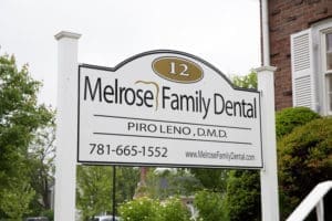 The entrance of Melrose Family Dental, featuring the clinic's signboard on the side, welcoming patients.