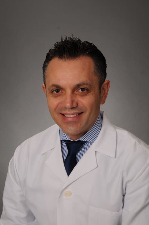 Dr. Piro Leno, DMD, a dedicated dentist, providing compassionate care to patients in the dental office.