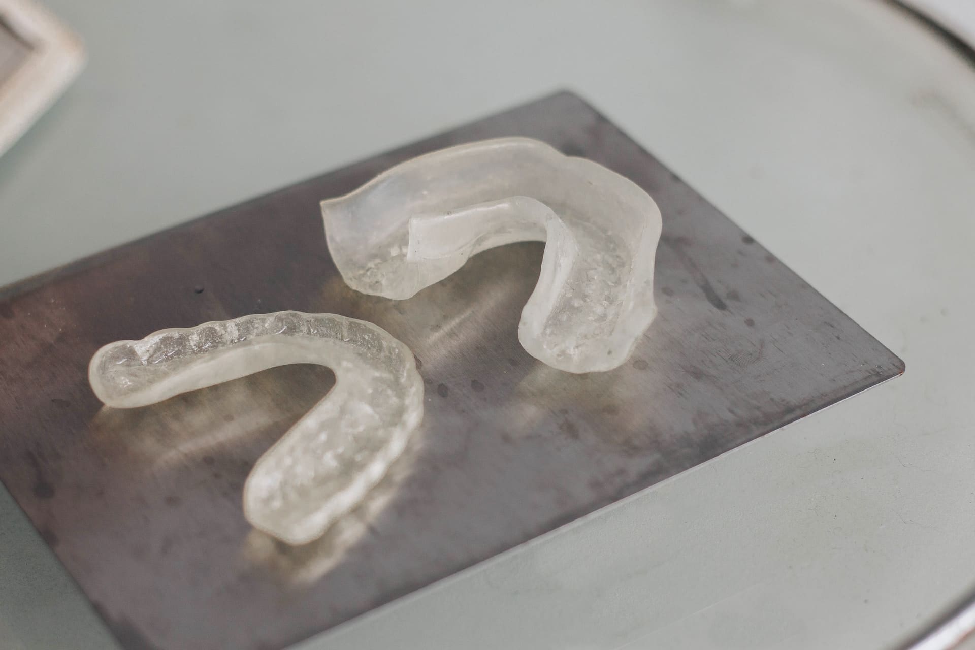 Close-up of clear Invisalign aligners being placed on a person's teeth.